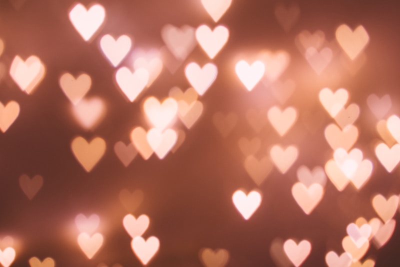 Soft bokeh heart-shaped lights in warm peach and pink tones